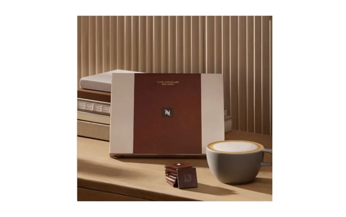 Шоколад Неспрессо и чашка капучино на столе.